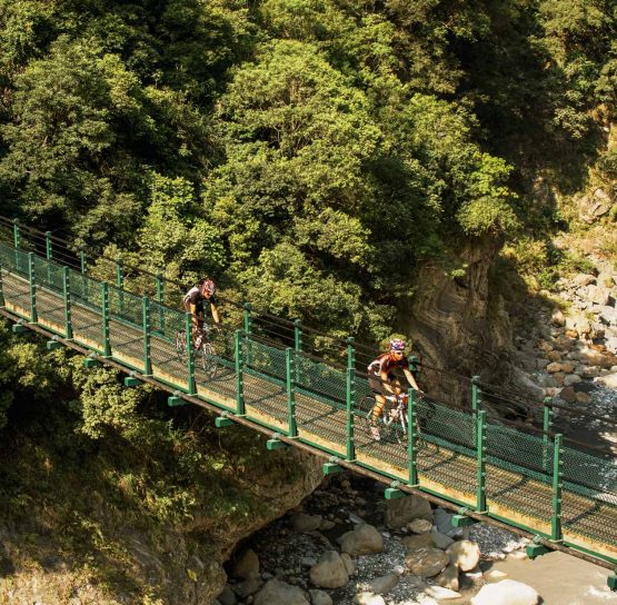 Bikers crossing bridge on Taiwan Bike Tour